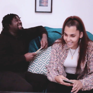 Terell And Beyonce from No Box No Label sit on a sofa and laugh